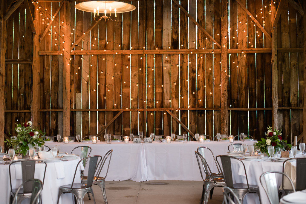 Edison Strands draped as wedding string lighting on a barn wall behind a head table