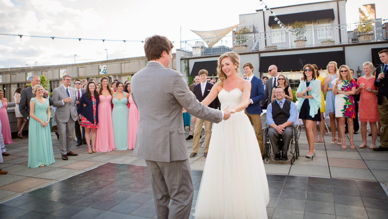 bride and groom dancing on terrace under bistro lights