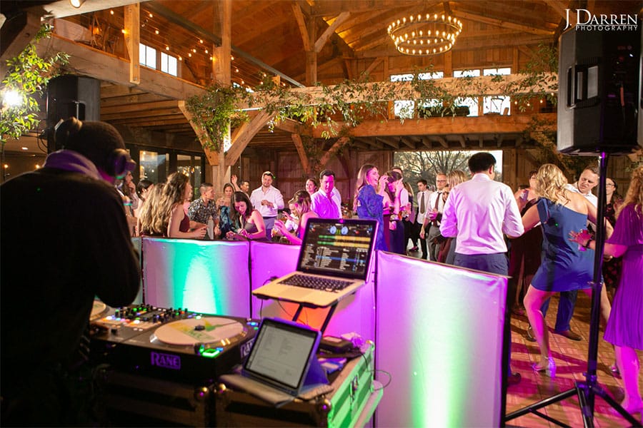 The DJ is playing music while the guests at the wedding dance. 