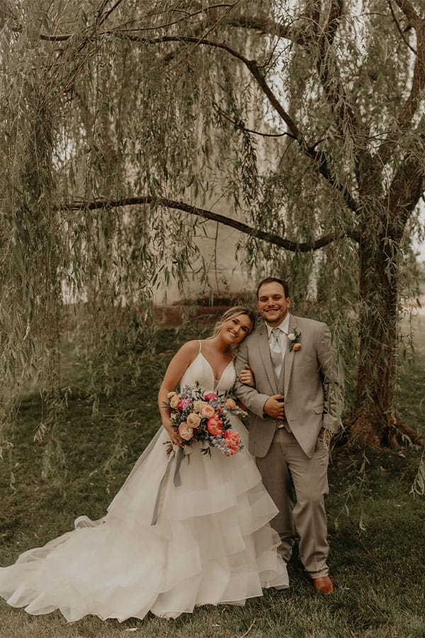 The bride and groom under a tree. 