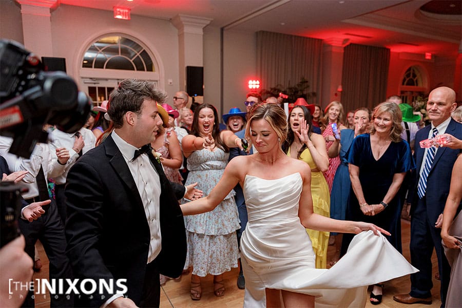 The bride and groom dancing with friends and family. 