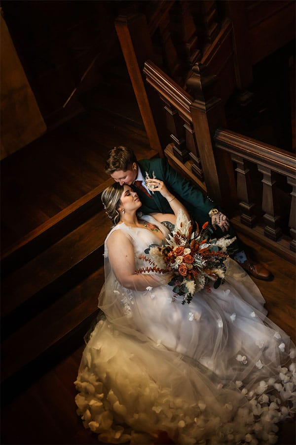 The couple laying on a beautiful stair case together. 