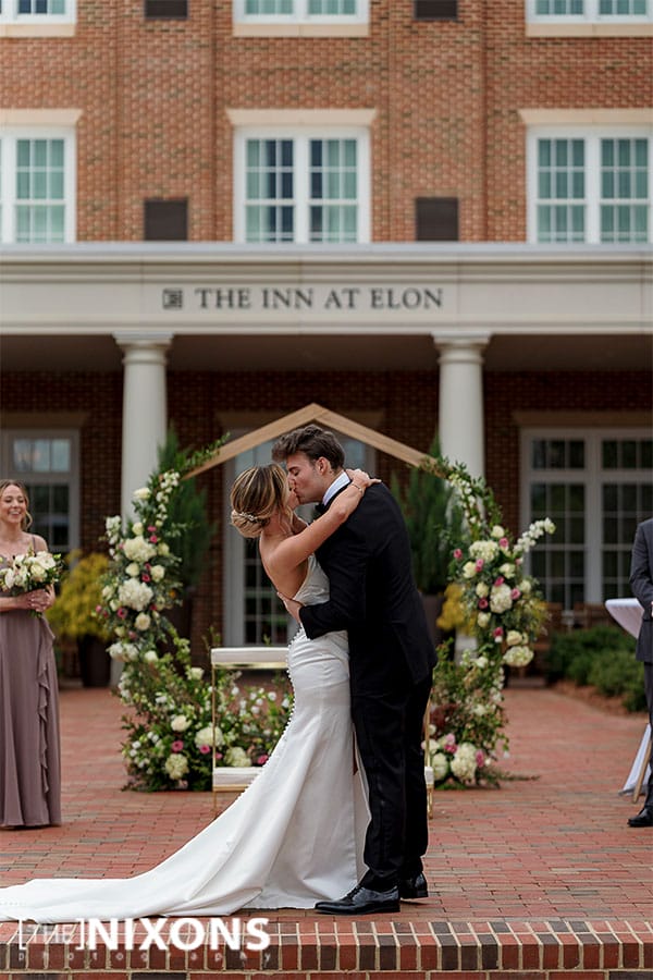 The bride and groom kissing at the alter.