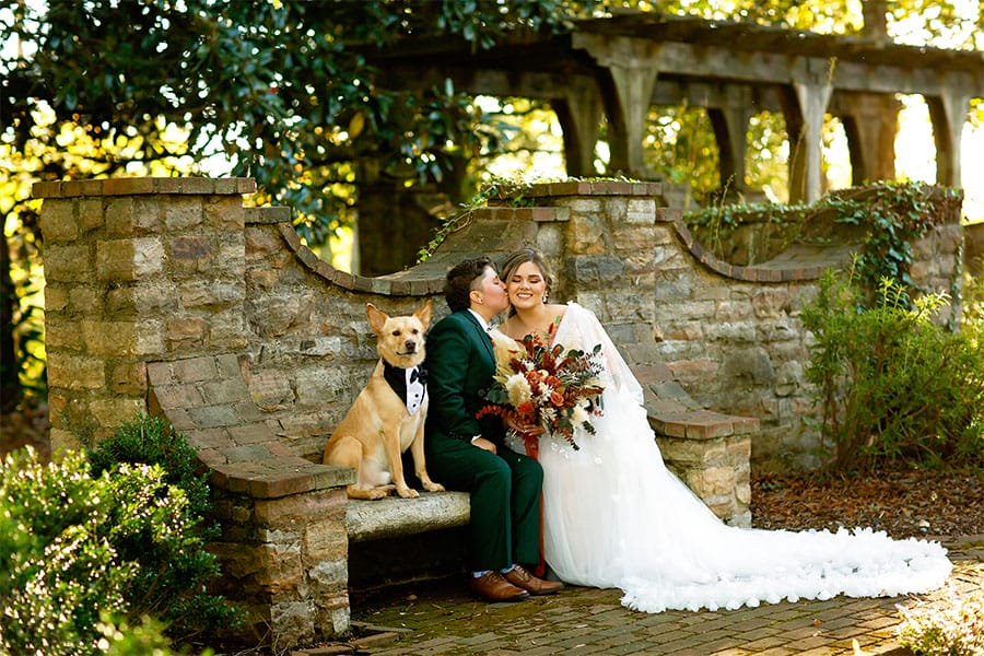 The brides sitting with there dog. 