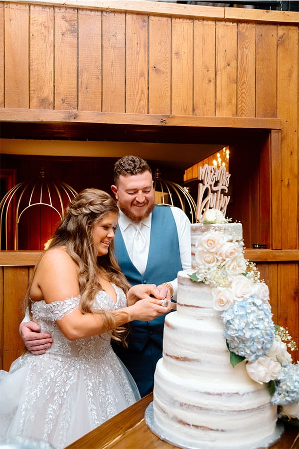 The bride and groom cutting their beautiful wedding cake. 