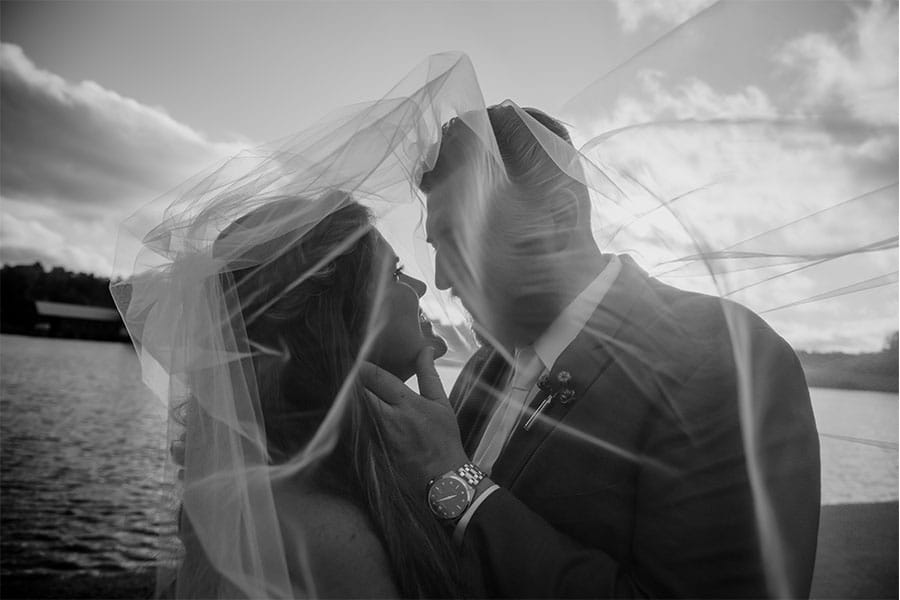 The bride and groom with a lake in the back ground. 