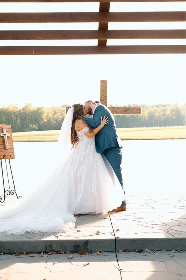 The bride and groom kissing at the alter.