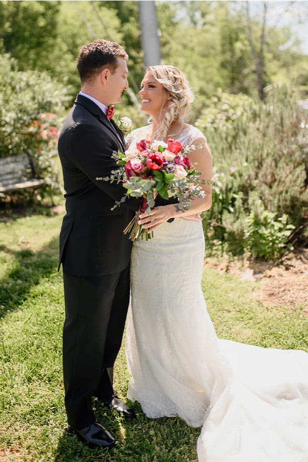 The bride and groom are holding flowers. 