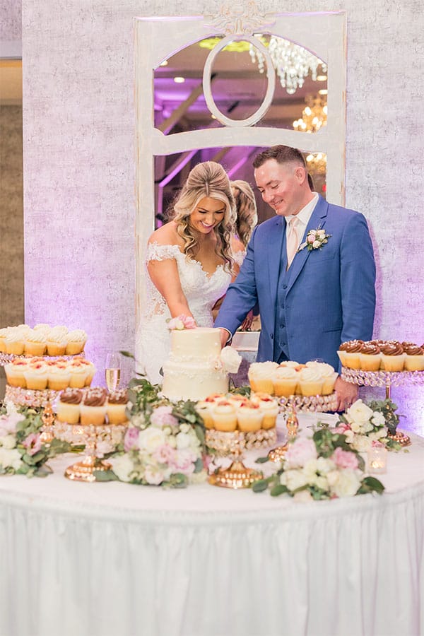 The bride and groom cutting their wedding cake. 