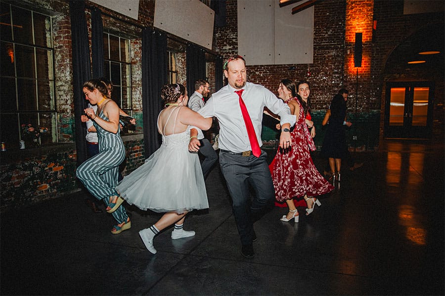 The bride and groom dancing with family and friends.