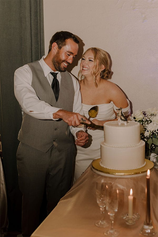 The bride and groom cutting the wedding cake. 