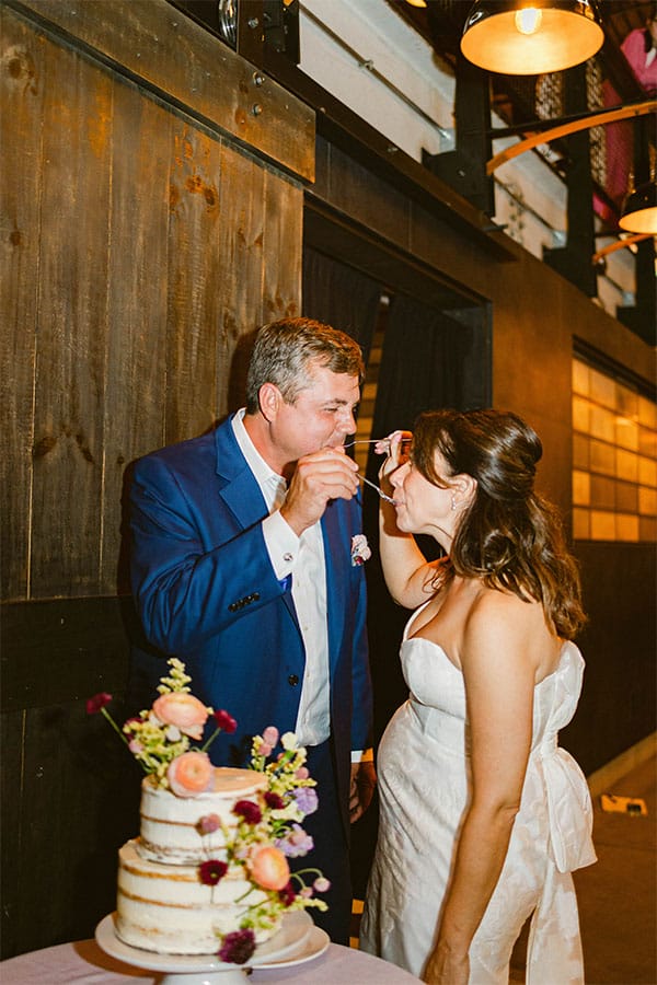 The bride and groom cutting their wedding cake. 