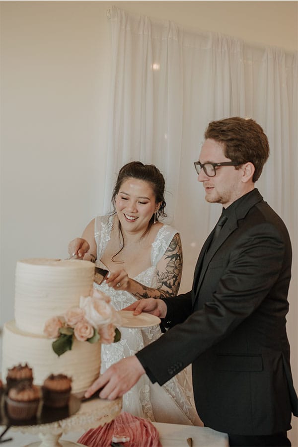 The bride and groom cutting their wedding cake.