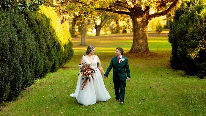 A couple walking and holding hands.