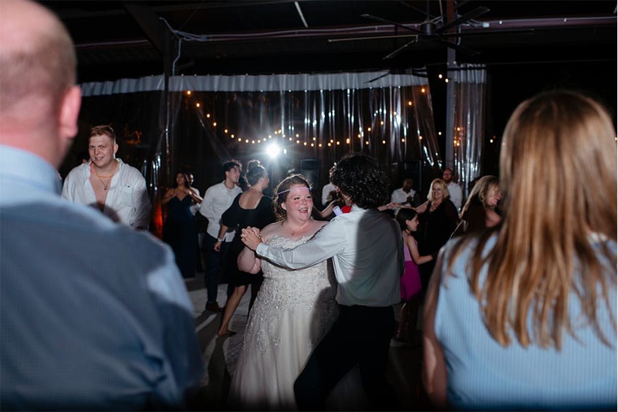 The bride and groom dancing with friends and family. 