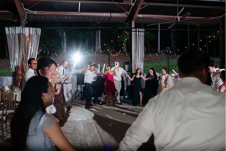 The bride and groom dancing with friends and family. 