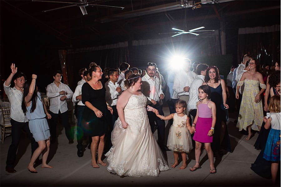 The bride and groom dancing with friends and family. 