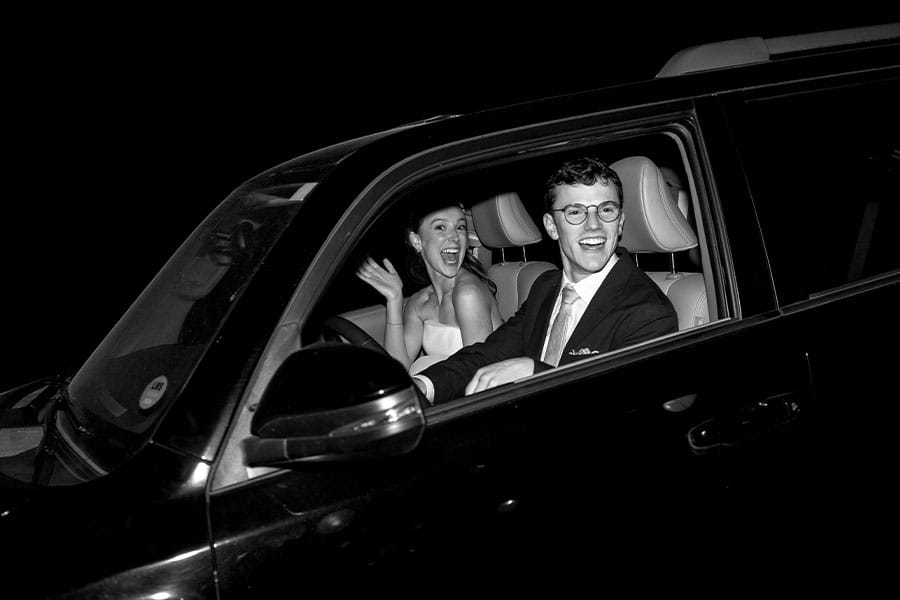 The bride and groom driving off after their wedding. 