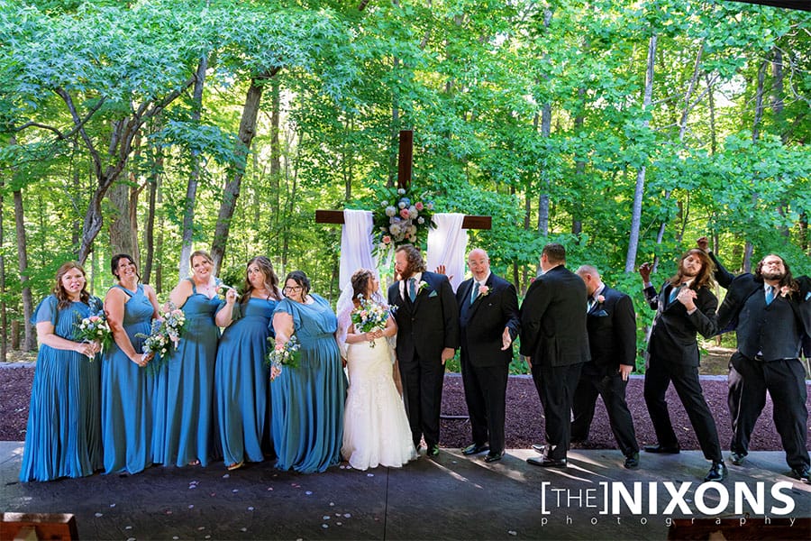 The bride and groom standing with their brides maids and grooms men.