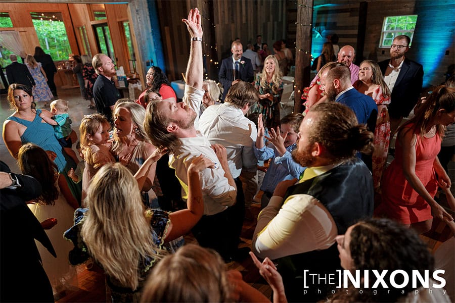 The bride and groom dancing with friends and family. 