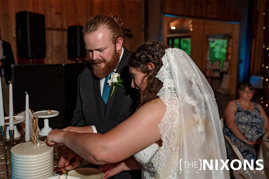 The bride and groom cutting their wedding cake. 