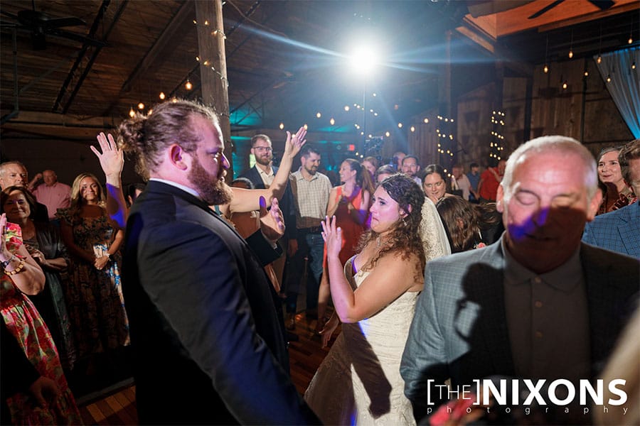 The bride and groom dancing with friends and family. 