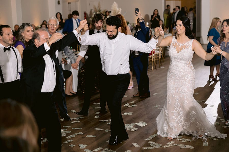 The bride and groom dancing with loved ones. 