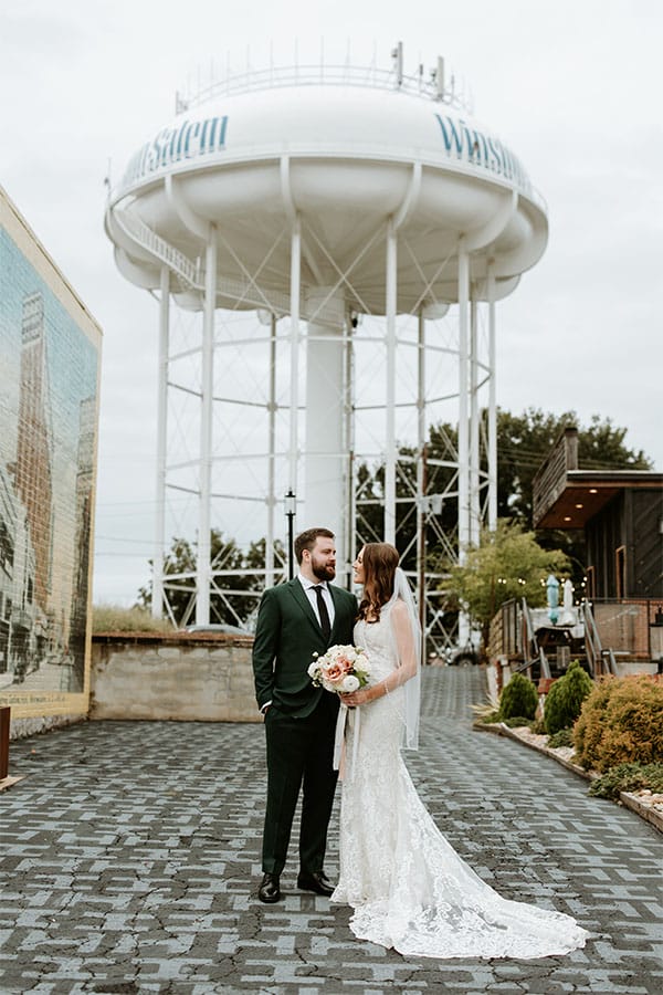 The bride and groom in front of a water tower.