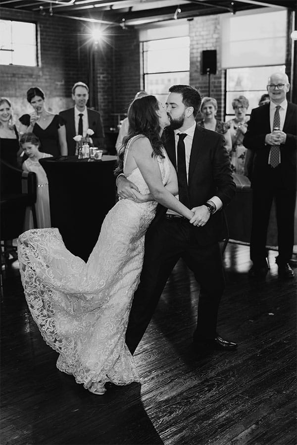 The bride and groom kissing and dancing.