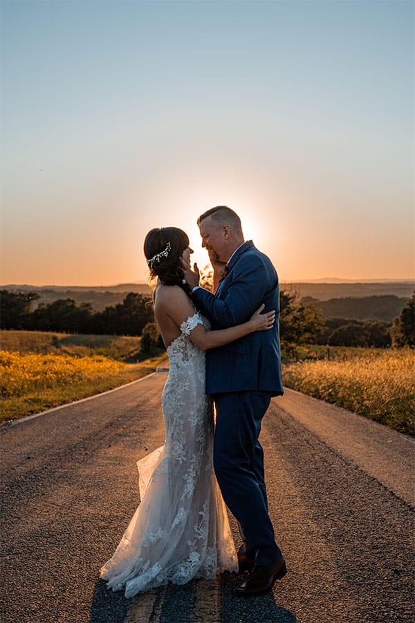 The bride and groom standing together iin the road.