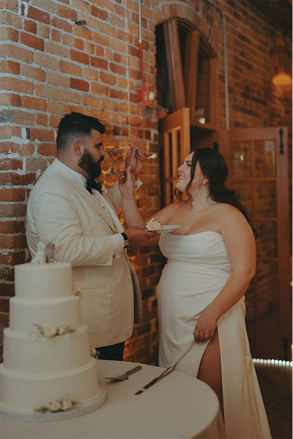 The bride and groom cutting their wedding cake. 