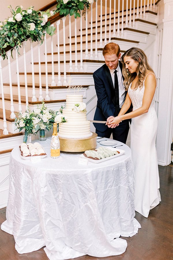 The bride and groom cutting their wedding cake. 