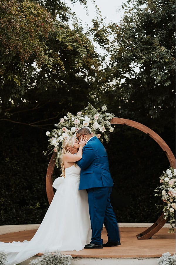 The bride and groom kissing at the alter. 