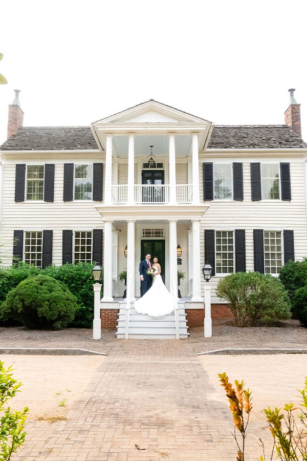 The bride and groom standing in front of the venue. 